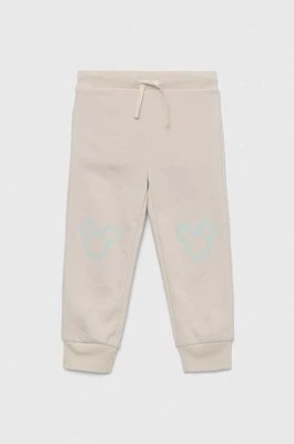 GAP spodnie dresowe dziecięce x Disney kolor beżowy z nadrukiem Gap